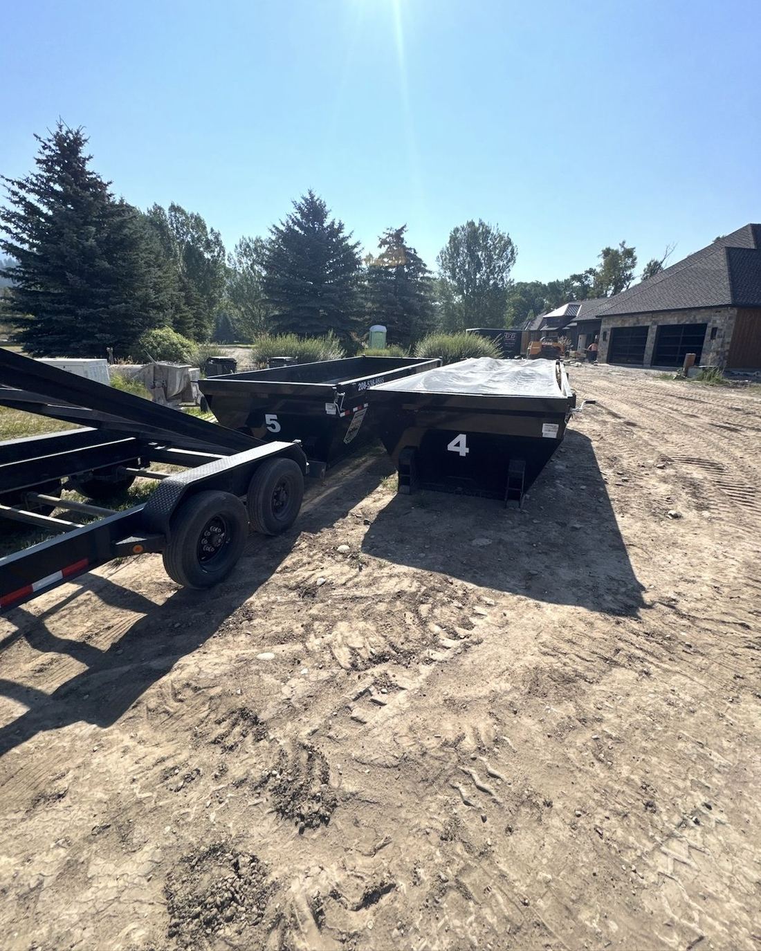 Roll-off dumpsters staged at a custom home site near Idaho Falls