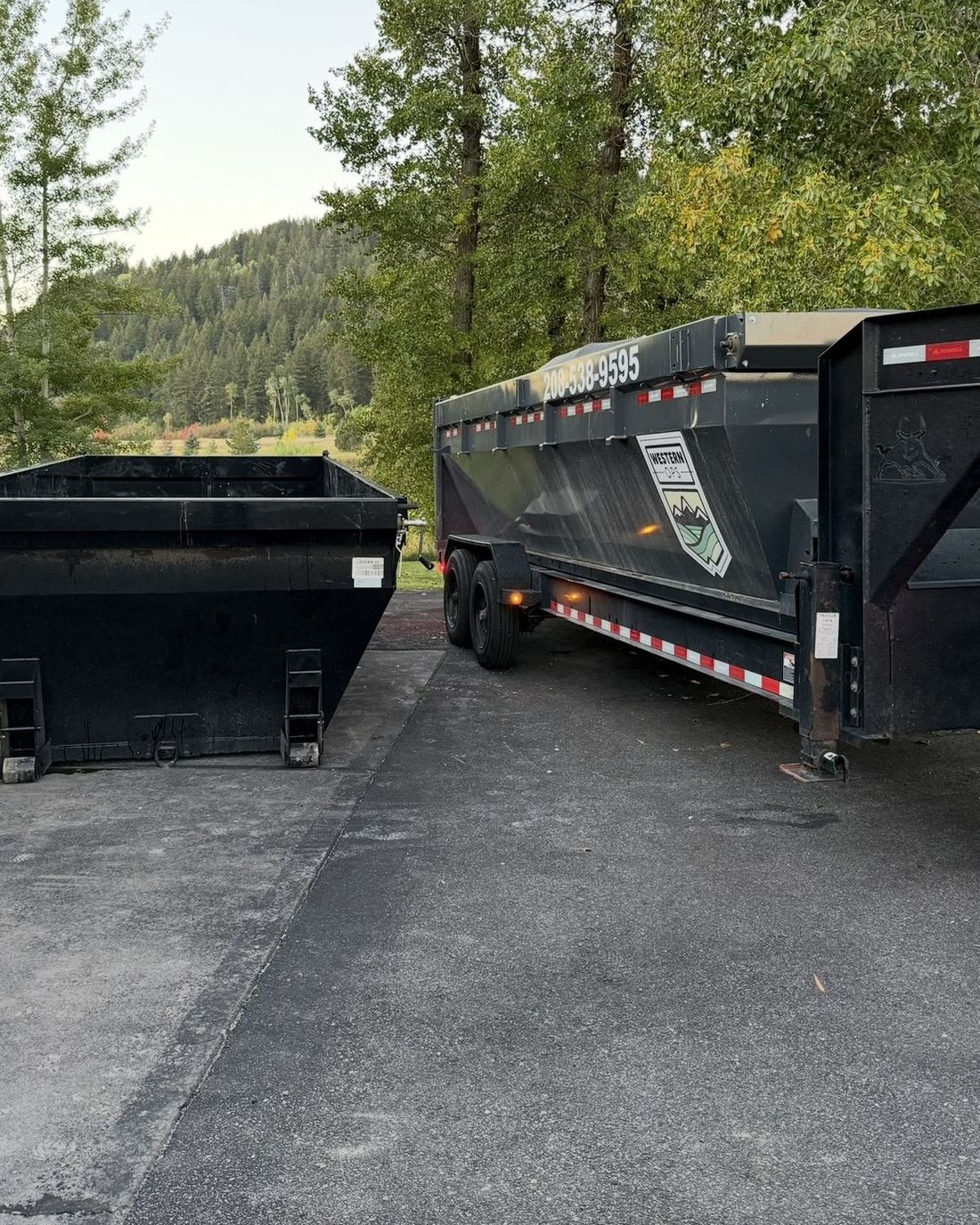 Roll-off dumpster and trailer on a mountain driveway in East Idaho