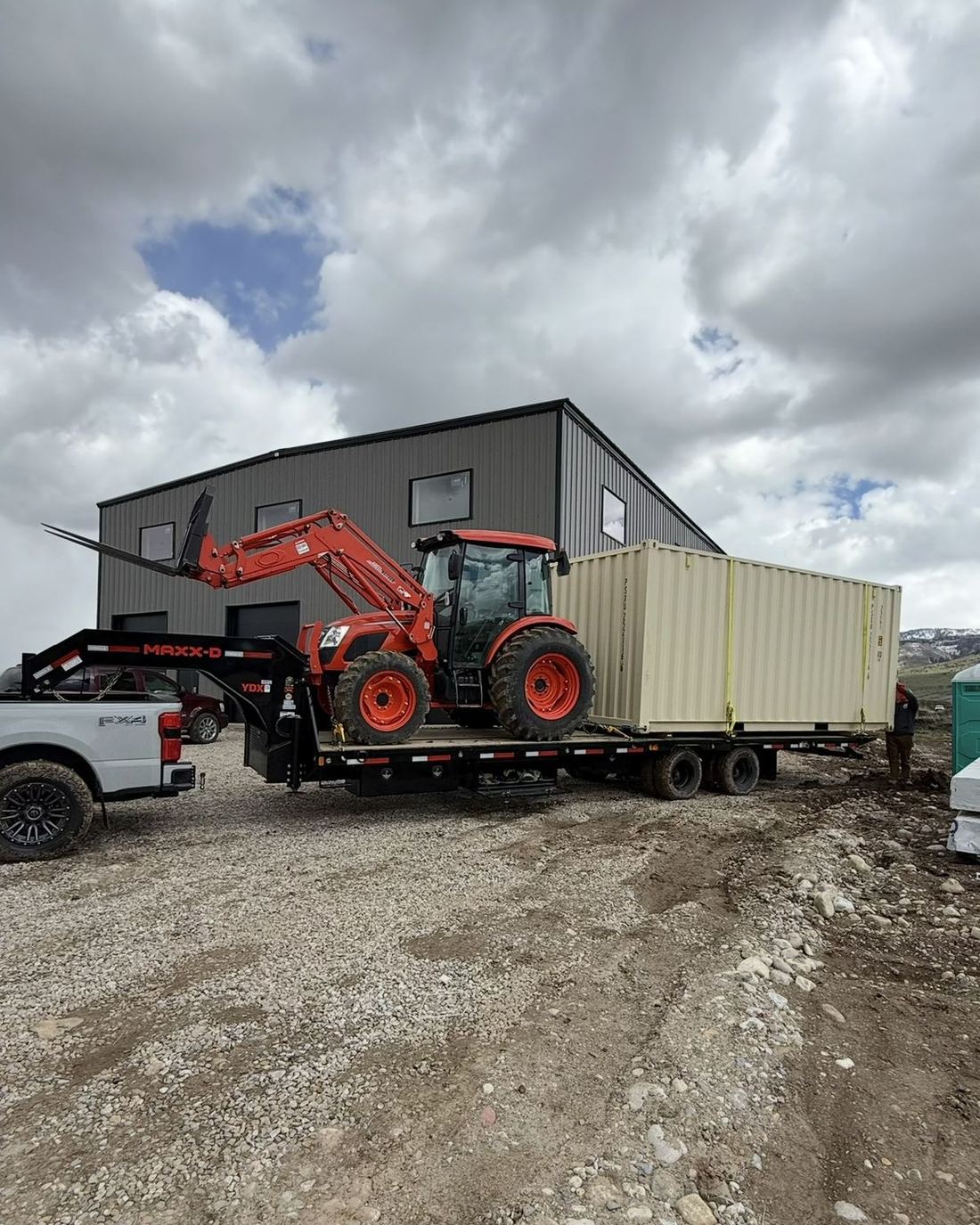 Unloading a storage container at the shop with the tractor